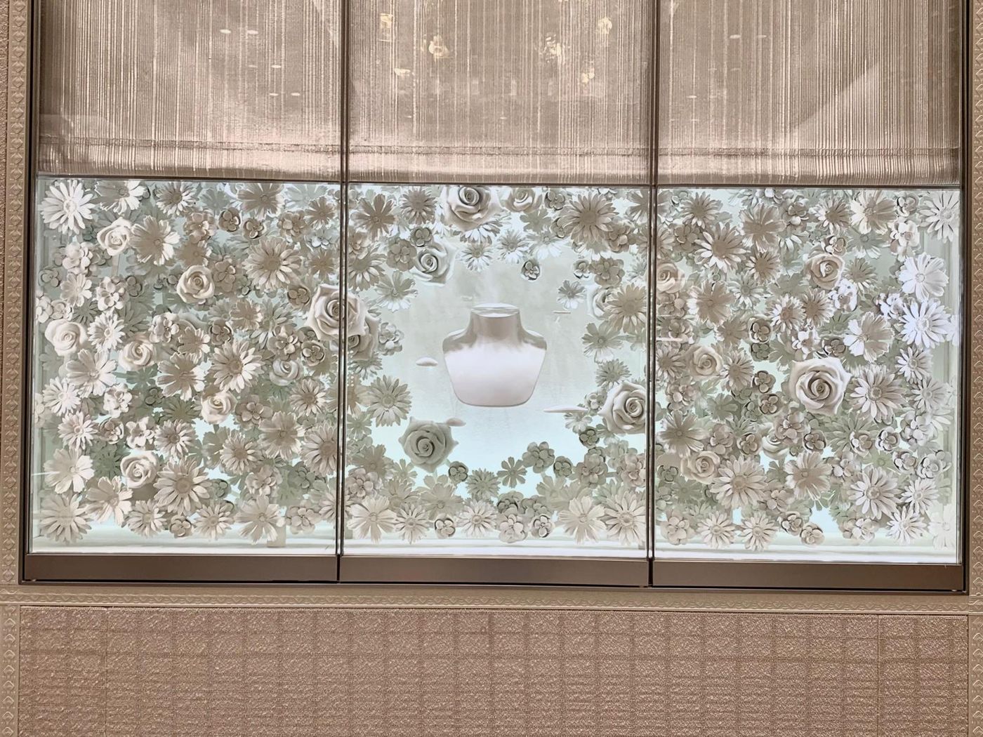 Escaparate frontal con flores y rosas blancas impresas en 3D alrededor de un busto expositor